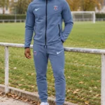 Survêtement PSG 2026/27 à capuche bleu gris · Adulte — Le modèle porté au bord du terrain