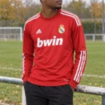 Maillot Real Madrid 2011/12 third rouge manches longues · Rétro — coupe joueur — Le modèle porté au bord du terrain